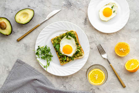 Open sandwich with avocado spinach cream and eggs. Top view