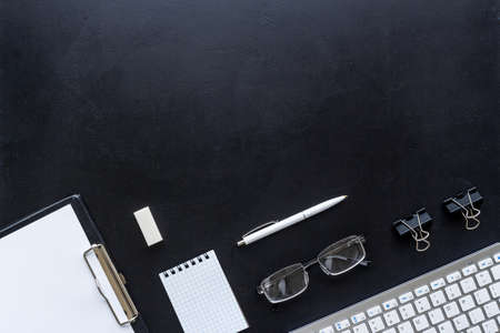 Top view of working place with computer keyboard and notepad