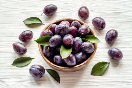 Purple plums in bowl. Plum harvest top viewの写真素材