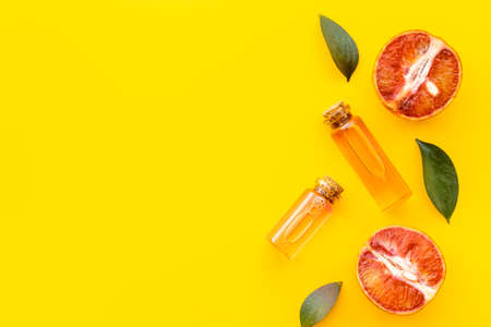 Grapefruit fragrance essential oil in bottles with fresh fruits. Top viewの写真素材