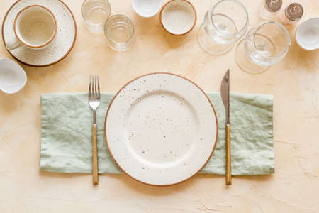 Tableware set with empty plate with dishware and glasses on napkinの写真素材