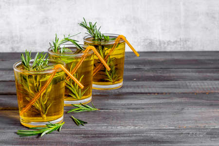 A lot of glasses of lemonade with cold tea and rosemaryの写真素材