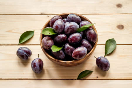 Purple plums in bowl. Plum harvest top viewの写真素材