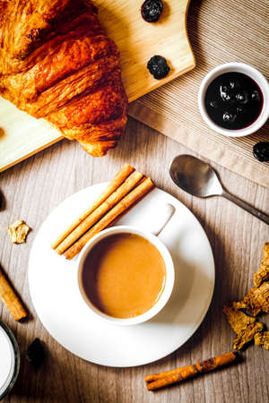 Breakfast with coffee and croissants on wooden table