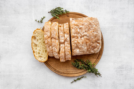 Sliced freshly backed bead ciabatta on cutting board, top view