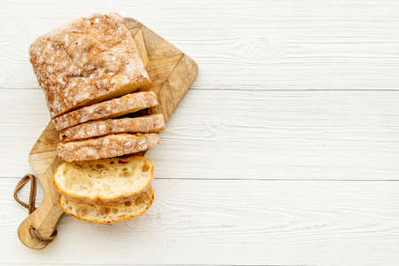 Freashly backed bread slice on cutting board, top view