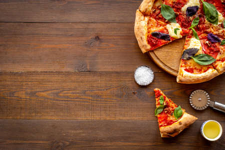 Sliced italian pizza margherita with tomatoes cheese and basil, top viewの写真素材