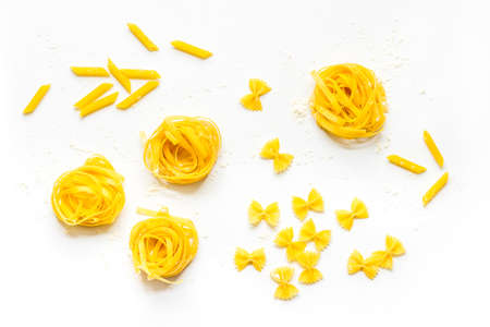 Different tipes of pasta with flour ready for cooking, flat layの写真素材