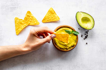 Avocado guacamole sause in bowl with nachos chipsの写真素材