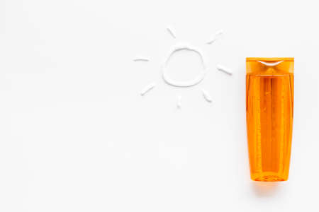 Sunscreen in bottles flatlay with sun made of white cream