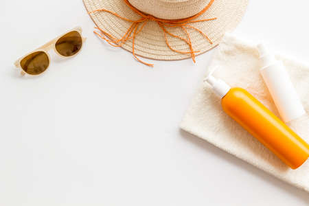 Summertime concept with straw hat and bottles od sunscreen