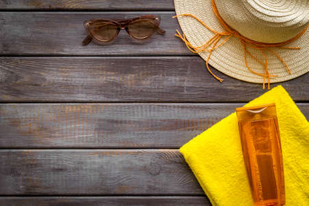Straw hat and suntanning lotion on towel. Skin care with UV protection cosmeticの写真素材