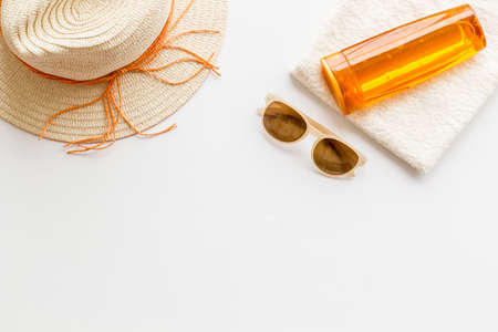 Skin care with sunscreen. Sun lotion and suglasses with straw hatの写真素材
