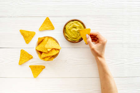 Avocado guacamole in bowl with corn nachos chips