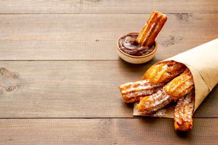 Street food dessert churros in paper bag with sugarの写真素材