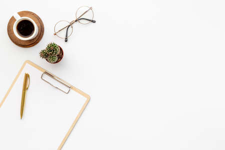 White office desk table with empty paper on clipboardの写真素材