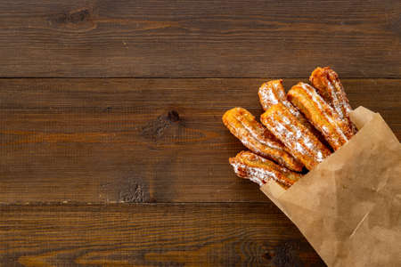 Street food dessert churros in paper bag with sugarの写真素材