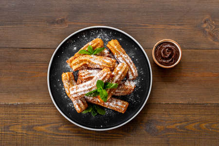 Churros with powdered sugar and chocolate sauce. Fast food sweetsの写真素材