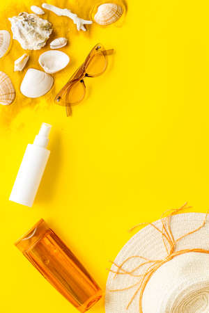 Flatlay of summer beach accessories with sand and seashells