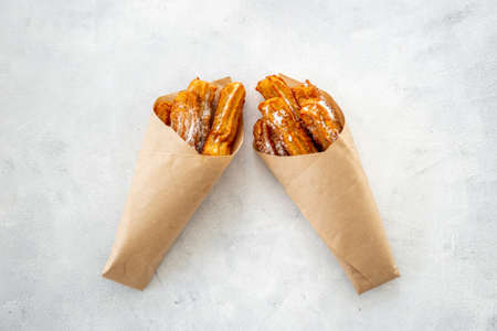 Street food dessert churros in paper bag with sugarの写真素材