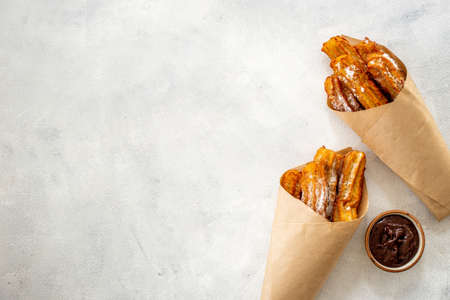Street food dessert churros in paper bag with sugarの写真素材