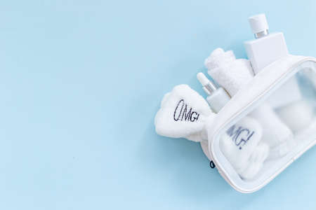Cosmetic bag with white cosmetic products, top view