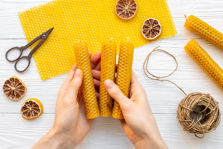 Hands making beeswax honey aroma candles with honeycombs, top viewの写真素材