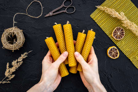 Hands making beeswax honey aroma candles with honeycombs, top viewの写真素材
