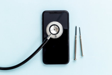 Electronics repair servise concept - mobile phone with stethoscopeの写真素材