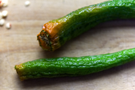 Dried green peppers on wooden boardの写真素材