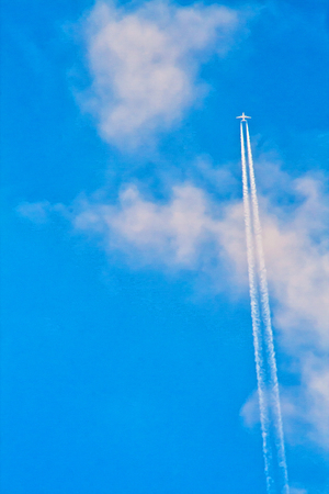 Airplane shooting upward with trailsの写真素材