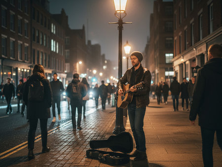 Young man playing guitar in the street at night. Street musician.の素材