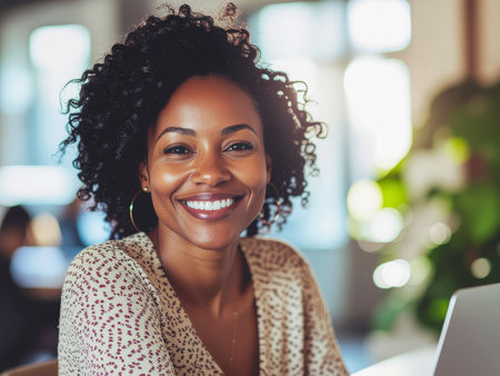 Portrait of smiling african american businesswoman using laptop in officeの素材