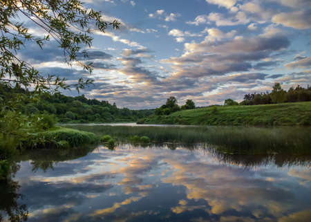 Reflection of clouds in the water. Early morning on the Ugra river.