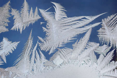Beautiful intricate patterns of frost on the glass in a cold winter day. Russia