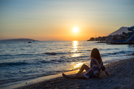 young woman on the beach at sunsetの写真素材