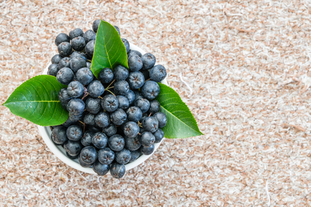 Chokeberry or Aronia melanocarpa in pot on textile background. Healthy fruitの写真素材