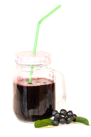 Fresh juice of chokeberry or Aronia melanocarpa in glass with straw and berry and leaves near, isolated on white background. Design element.の写真素材