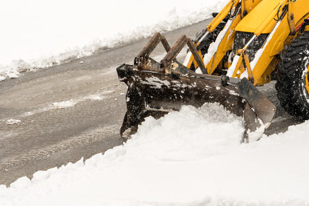 Snow removal. Wheel loader machine or vehicle removing snow from the roads in winter.の写真素材
