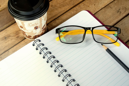 Notebook with a pencil and glasses.の写真素材