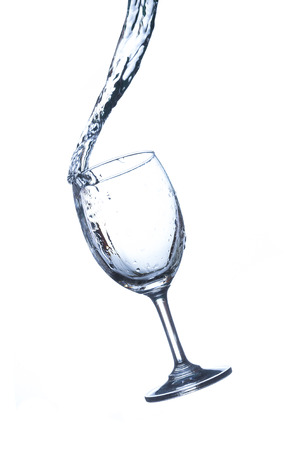Concept of drinking. Wine glass with splash water on white backgroundの写真素材