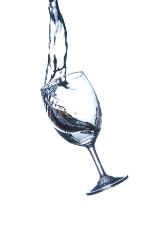 Concept of drinking. Wine glass with splash water on white backgroundの写真素材
