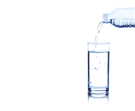 Concept of drinking. Pouring water from into glass on white background with blank areaの写真素材