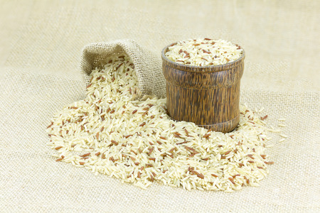 Rice in burlap sack and wood bowl on Sackの写真素材