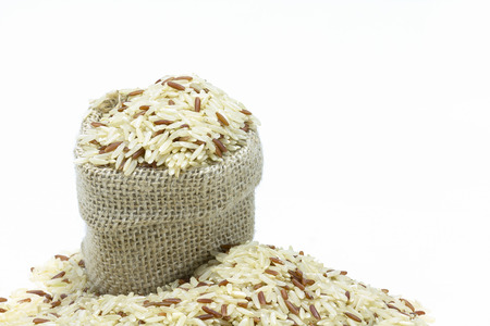 Rice in sack burlap on white backgroundの写真素材