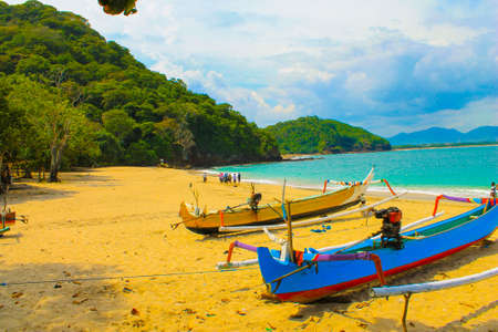 Indonesian beach with beautiful tropical scenery, there are fishing boats, beach sand, and small islandsの写真素材