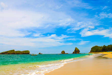 Indonesian beach with beautiful tropical scenery, there are fishing boats, beautiful big rocks and small islandsの写真素材