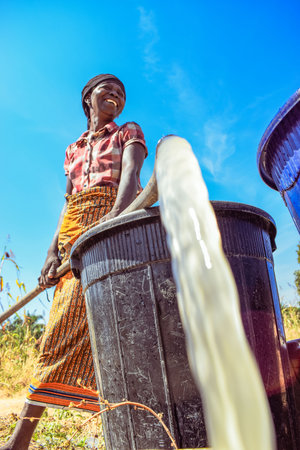 An African woman is washing a bucket of water for domestic useのeditorial素材