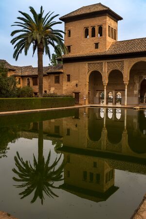Alhambra, Granada, Spain, September, 23, 2017: A large central pond faces the arched portico behind...