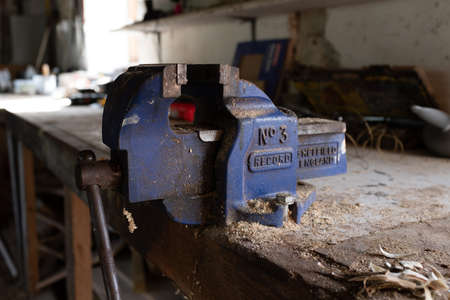 Ottery St Mary, Devon, Engalnd, March, 2, 2019: A close up of a used working bright blue vice on a...